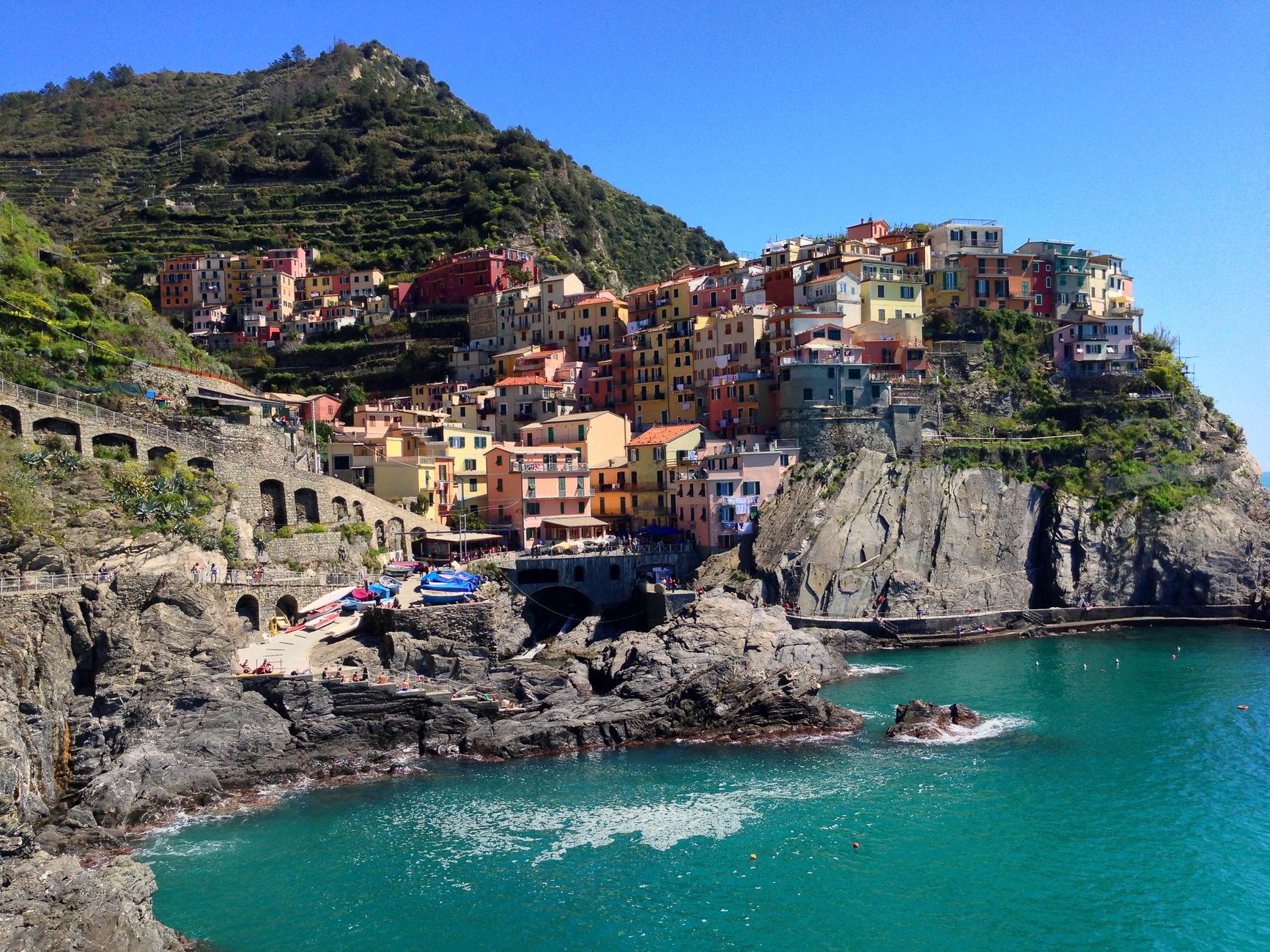 Colorful buildings of Manarola village stacked along rugged Mediterranean cliffs in Cinque Terre, Italy — a quintessential port of call on Italian Riviera cruise itineraries