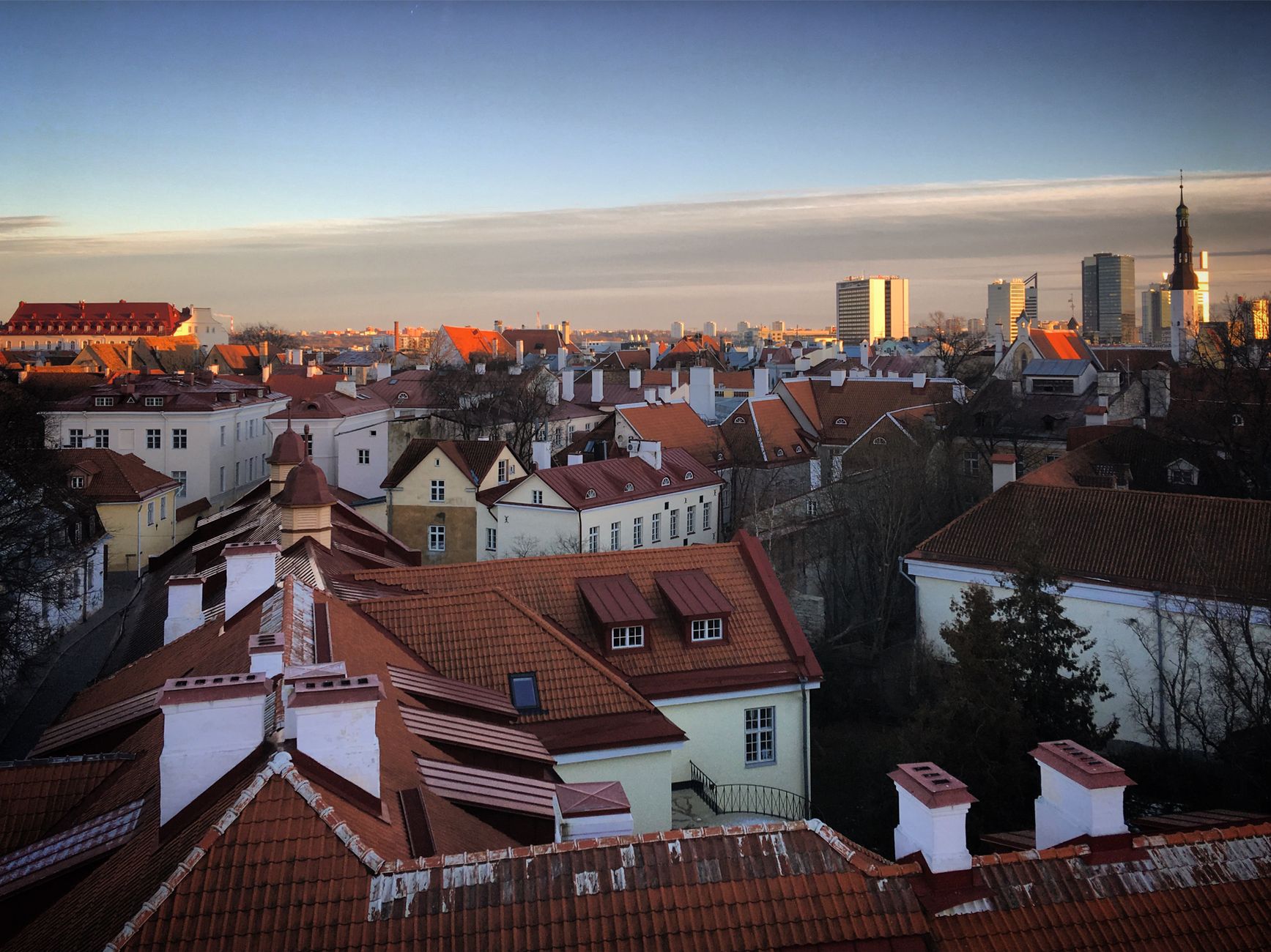 Aerial view of Tallinn's Old Town at sunset, showcasing its medieval red rooftops, church spires, and modern skyline — a quintessential Baltic capital on Copenhagen cruise itineraries.