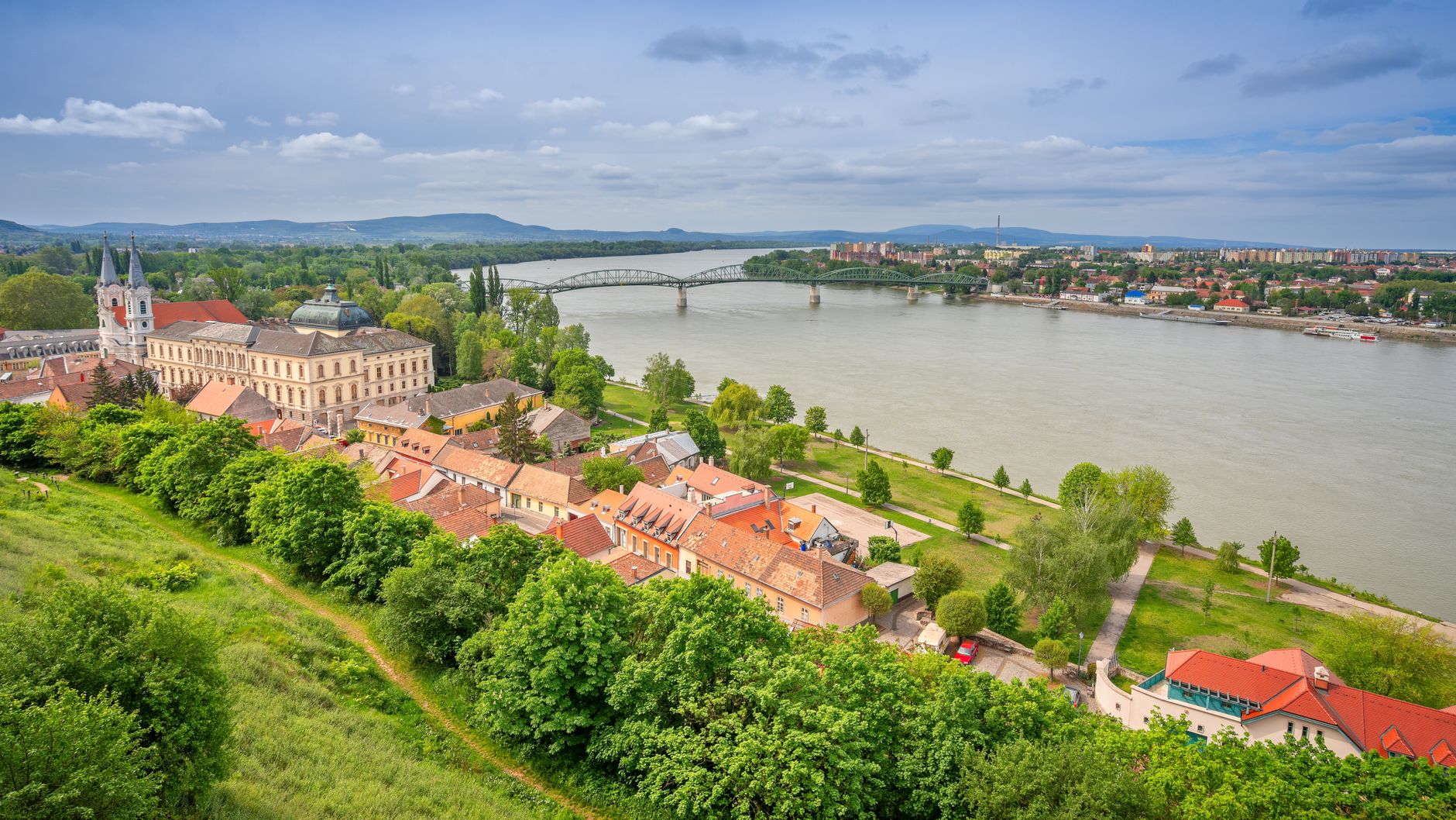 Aerial view of the historic town of Esztergom along the Danube River in Hungary, showcasing riverside architecture and landmark buildings — a classic European river cruise destination reachable from Bucharest.