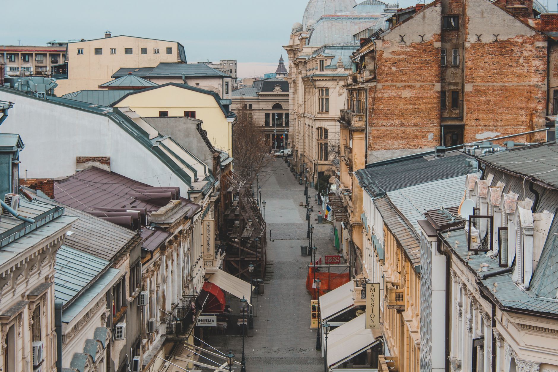 A historic street in downtown Bucharest's old town showcasing classic European Belle Époque architecture, capturing the textured charm of Romania's capital