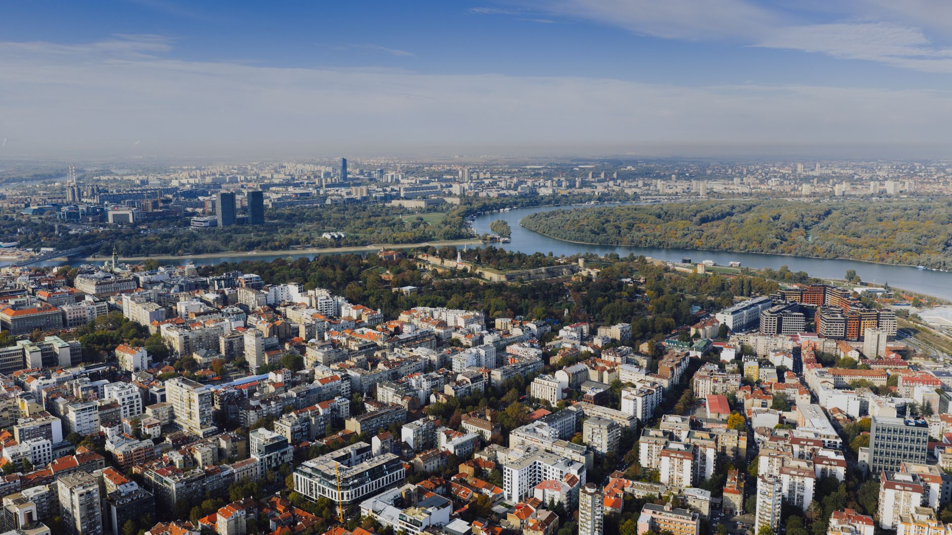 Aerial view of Belgrade's cityscape stretching along the Danube river, showcasing the Serbian capital's skyline as seen from the waterway on a Danube river cruise route.