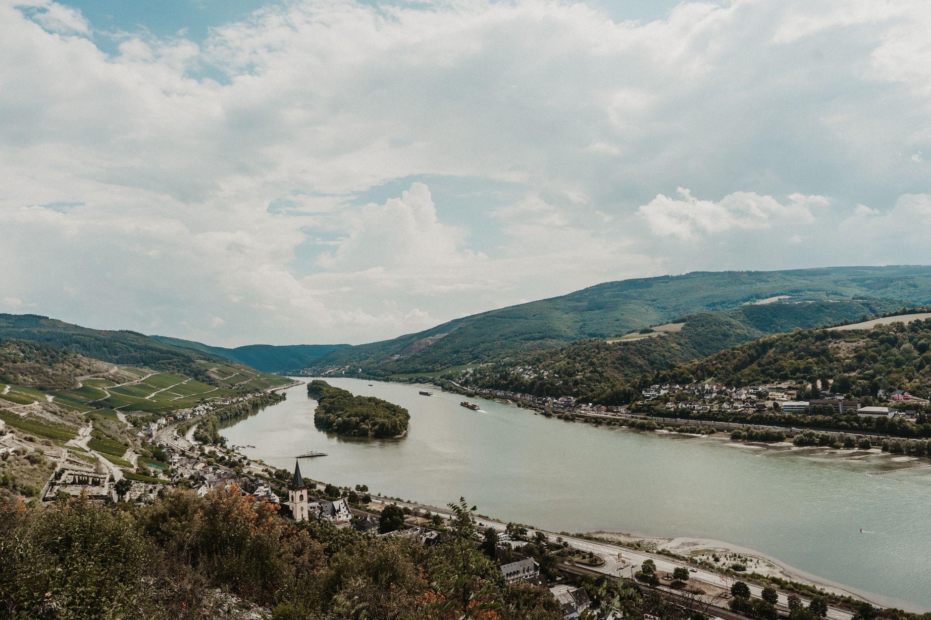 Aerial view of the Rhine River winding through the picturesque town of Rüdesheim, Germany, surrounded by vineyard-covered hills — a quintessential Northern European river cruise destination accessible from Antwerp.