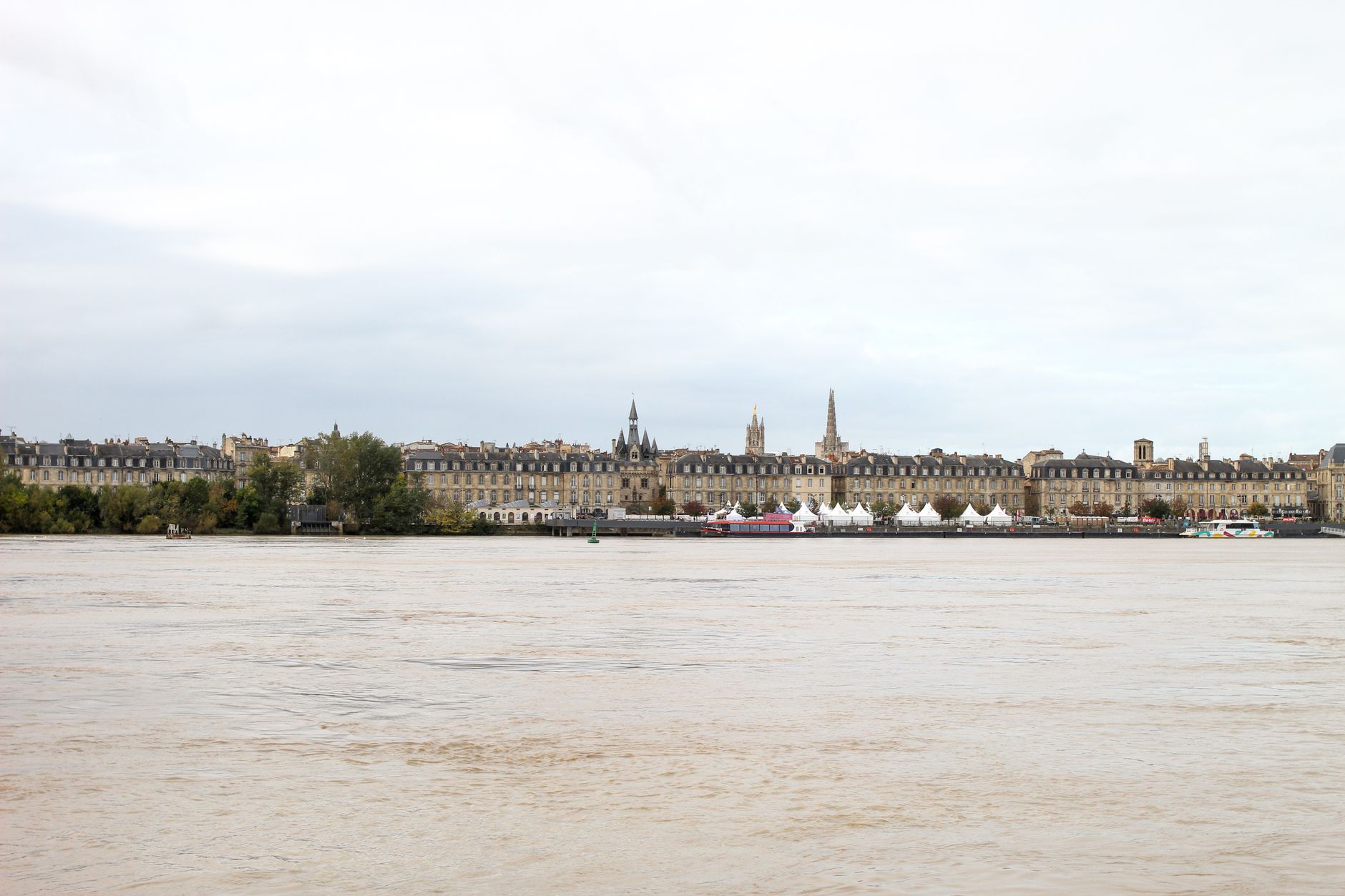 Historic neoclassical architecture lining the Bordeaux riverbank along the Garonne, capturing the elegant waterfront facades that greet river cruise passengers arriving in France's wine capital.