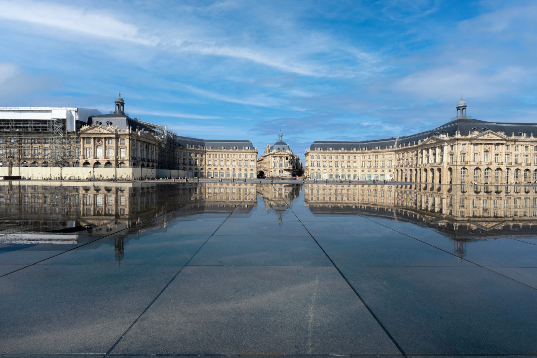 Neoclassical façades of Place de la Bourse in Bordeaux reflected on the calm water mirror surface, showcasing the elegant 18th-century architecture of this iconic river cruise departure city