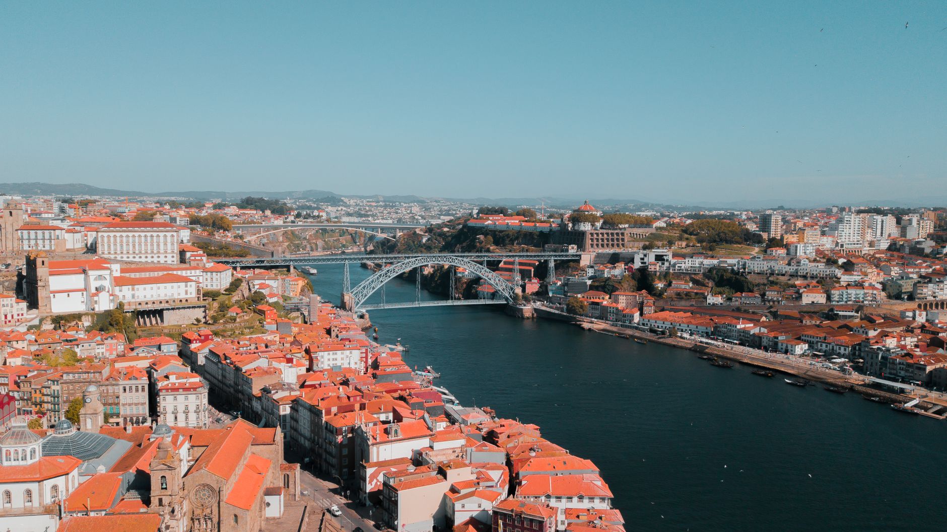 A breathtaking aerial view of Porto, Portugal, featuring the iconic Luís I Bridge and Douro River.