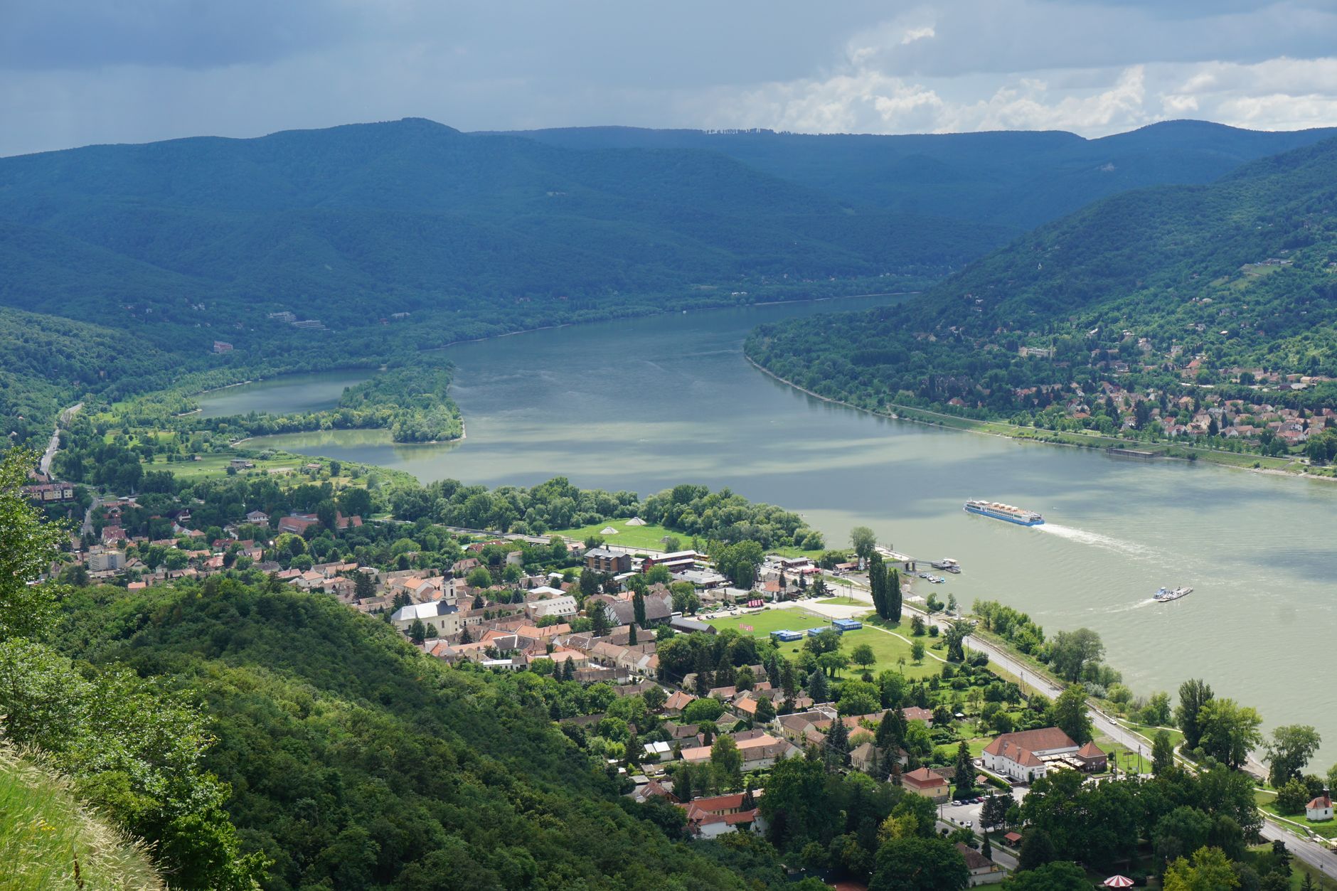 Aerial view of the Visegrád Bend where the Danube River curves dramatically through lush green hills in Hungary, capturing the iconic river gorge landscape featured along this cruise route.
