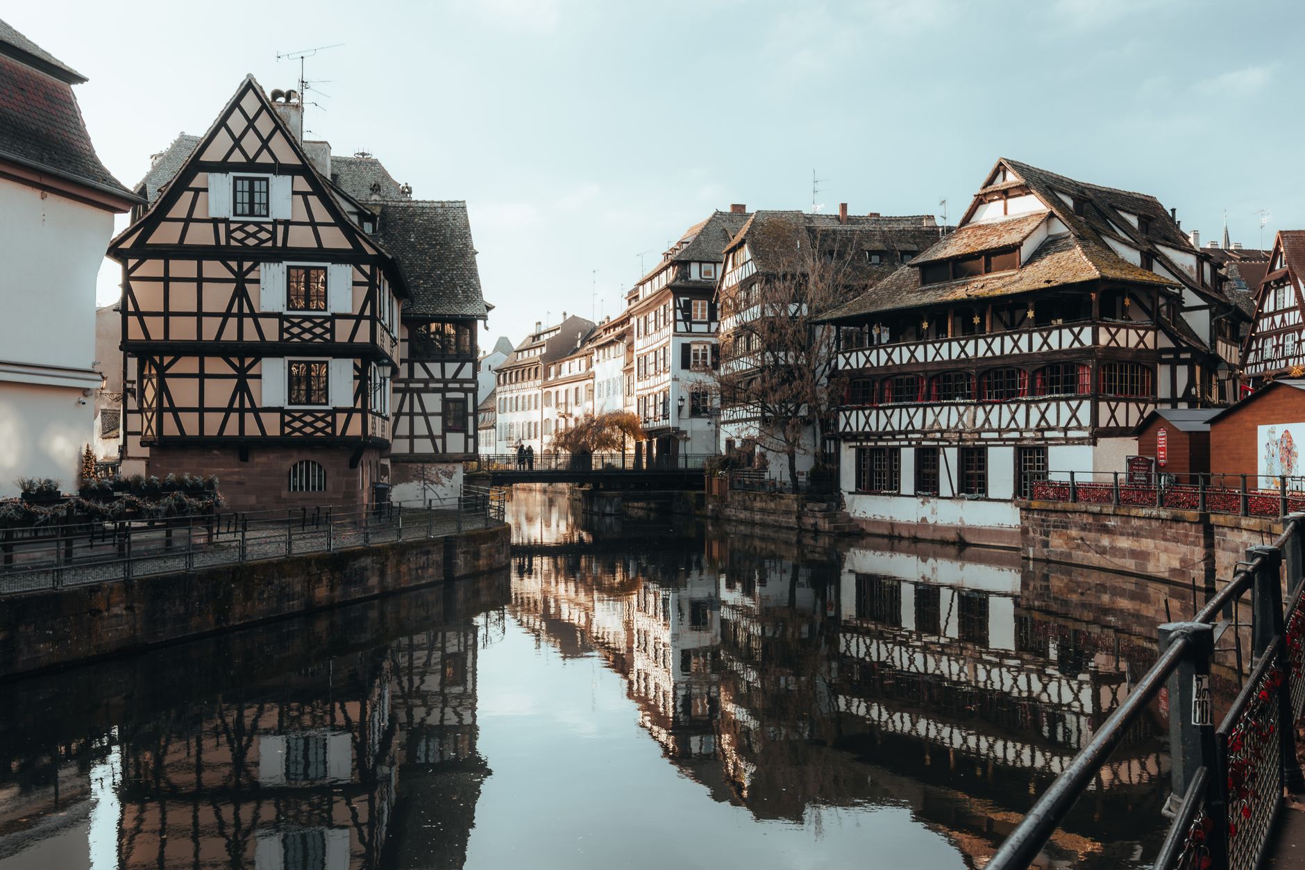 Half-timbered houses in Strasbourg's Petite France district reflected in a tranquil canal, illustrating the walkable, picturesque shore excursion destinations along the Rhine route.