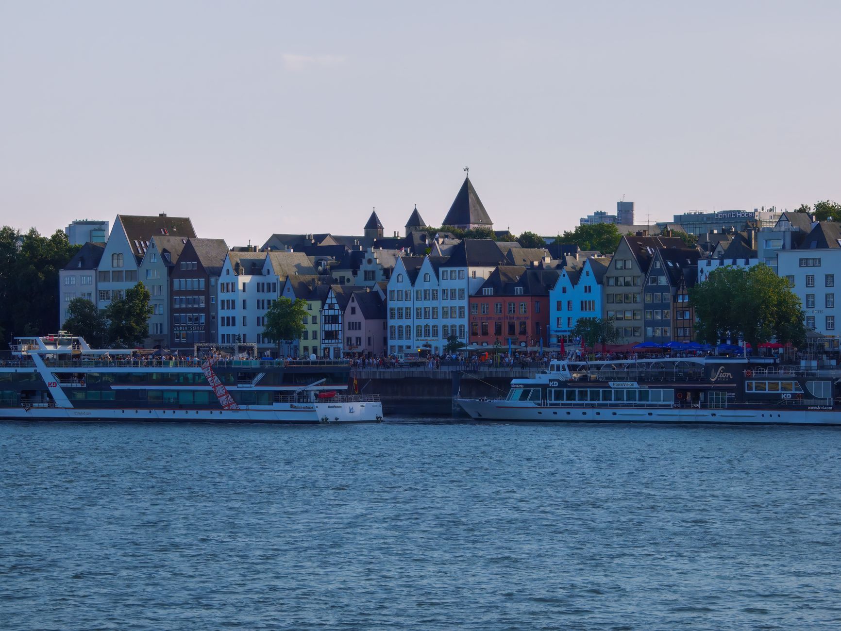 Charming waterfront along the Rhine River featuring colorful historic buildings and boats, a classic European cruise destination accessible from Zurich