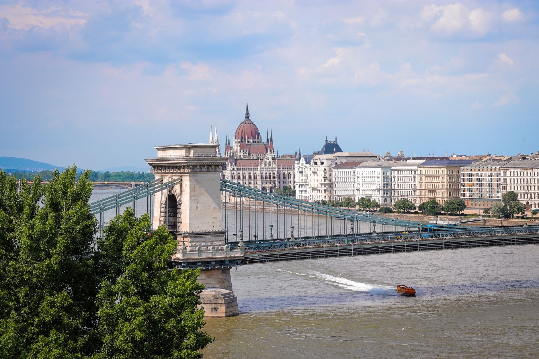 The Széchenyi Chain Bridge stretches across the Danube River with the Hungarian Parliament Building rising in the background, capturing Budapest's iconic riverside landmarks along a popular European river cruise route from Vilshofen.
