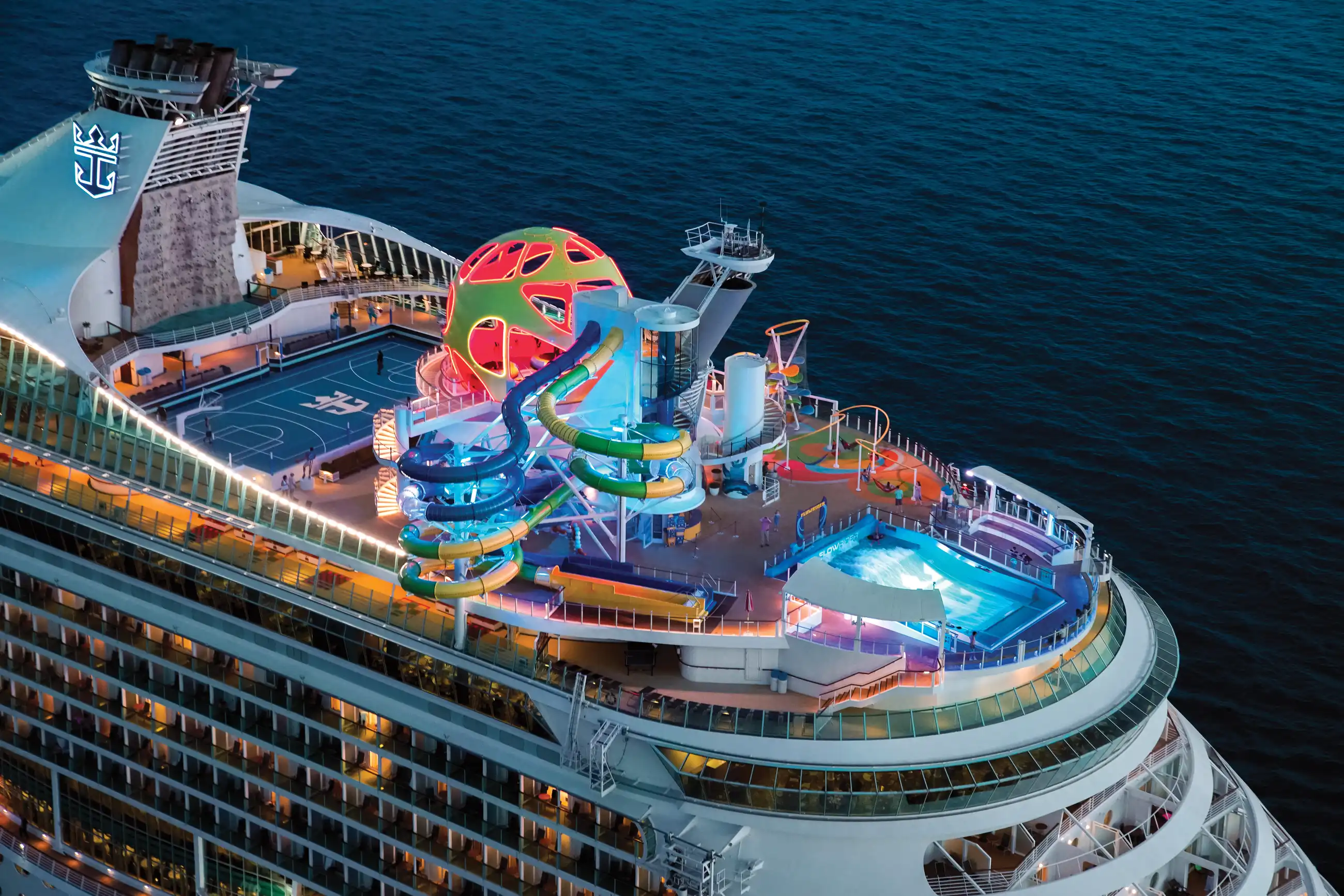 Aerial view of Mariner of the Seas' upper decks, with the red-and-yellow dual-lane waterslide, splash pad and pools.