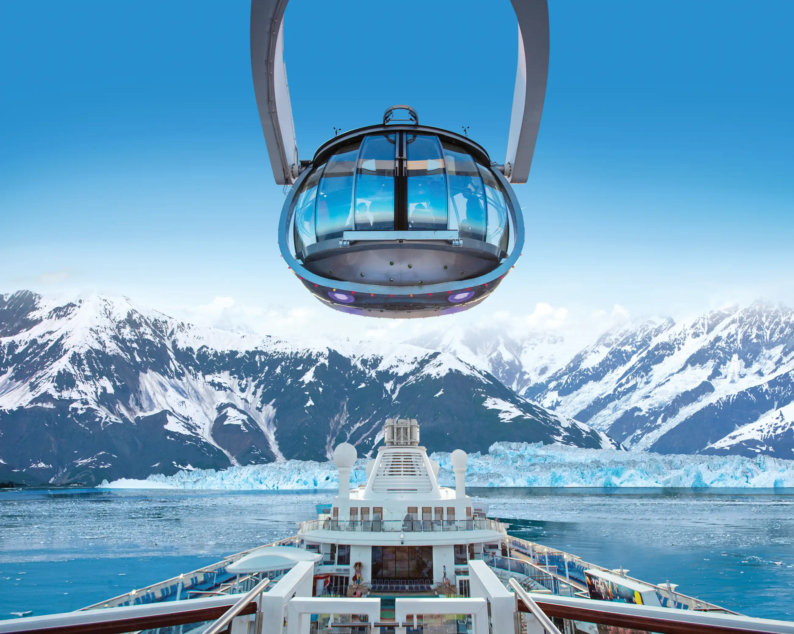The glass North Star observation capsule suspended above the bow of Ovation of the Seas, with a glacier-fed Alaskan bay and snow-capped peaks below.