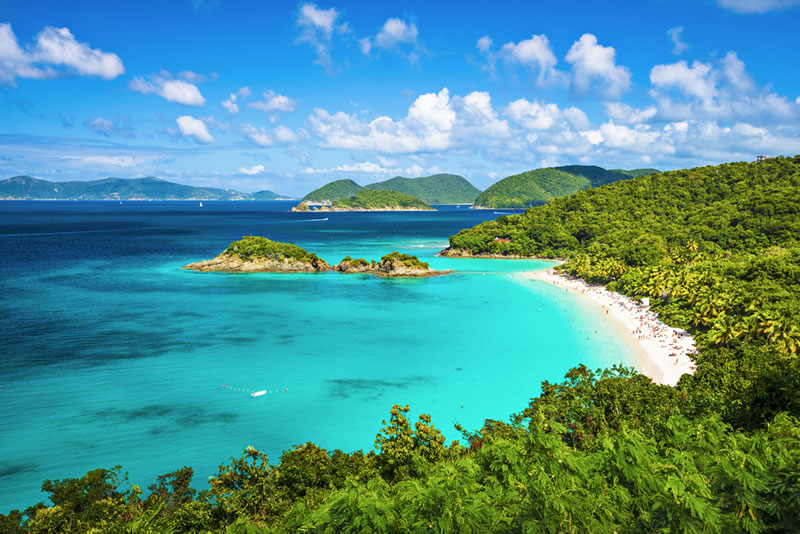 Tropical paradise with turquoise waters, white beach, and lush green islands
