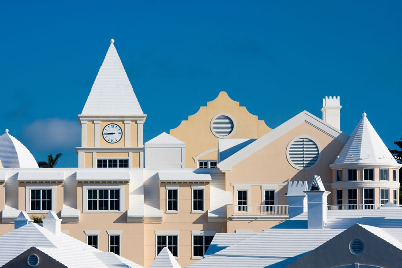 White-roofed Bermuda buildings with yellow walls and clock tower