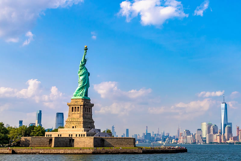 Statue of Liberty with New York City skyline on a sunny day