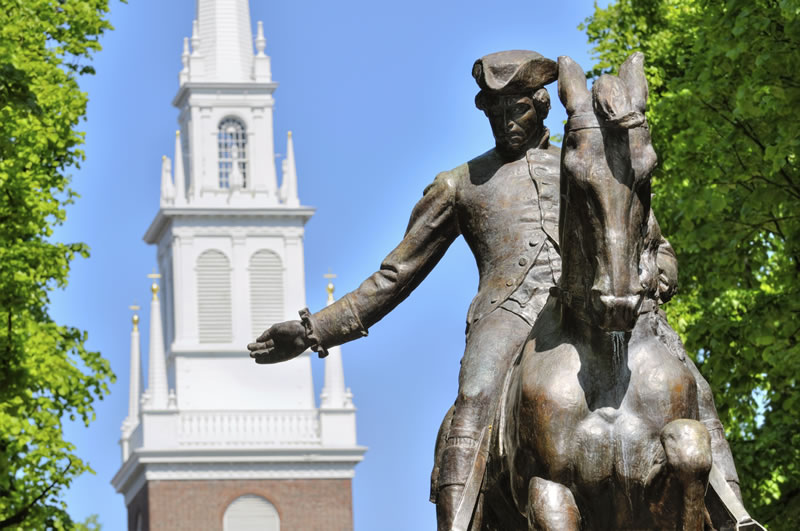 Bronze statue of Revolutionary War rider near historic church tower