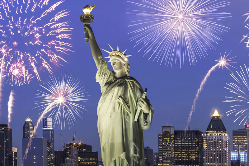 Statue of Liberty with fireworks over New York City skyline at night