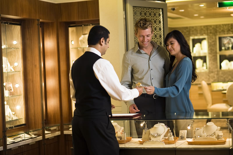 Couple shopping for jewelry with help from a store employee