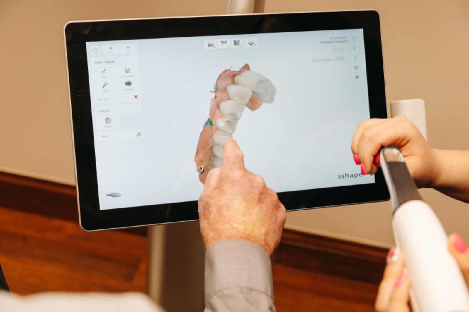Dental professional pointing to jaw anatomy on digital display