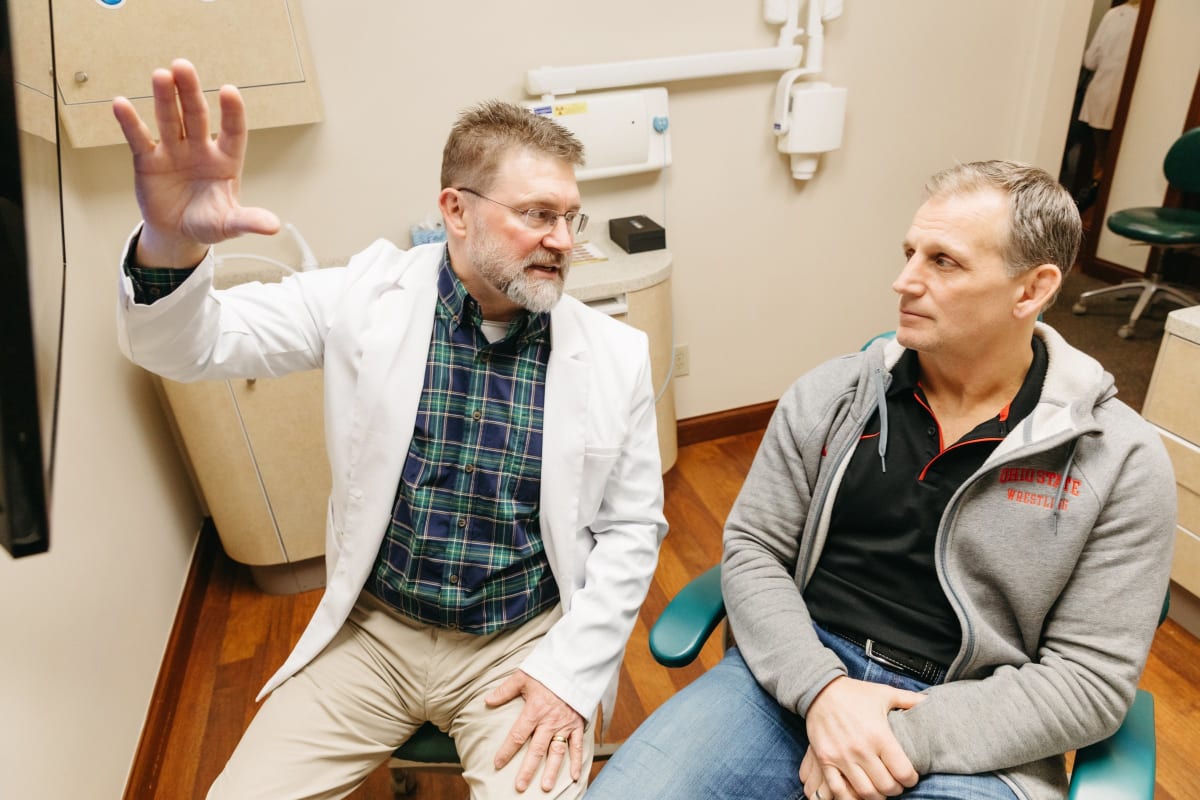 Dentist explaining jaw joint anatomy to patient during consultation