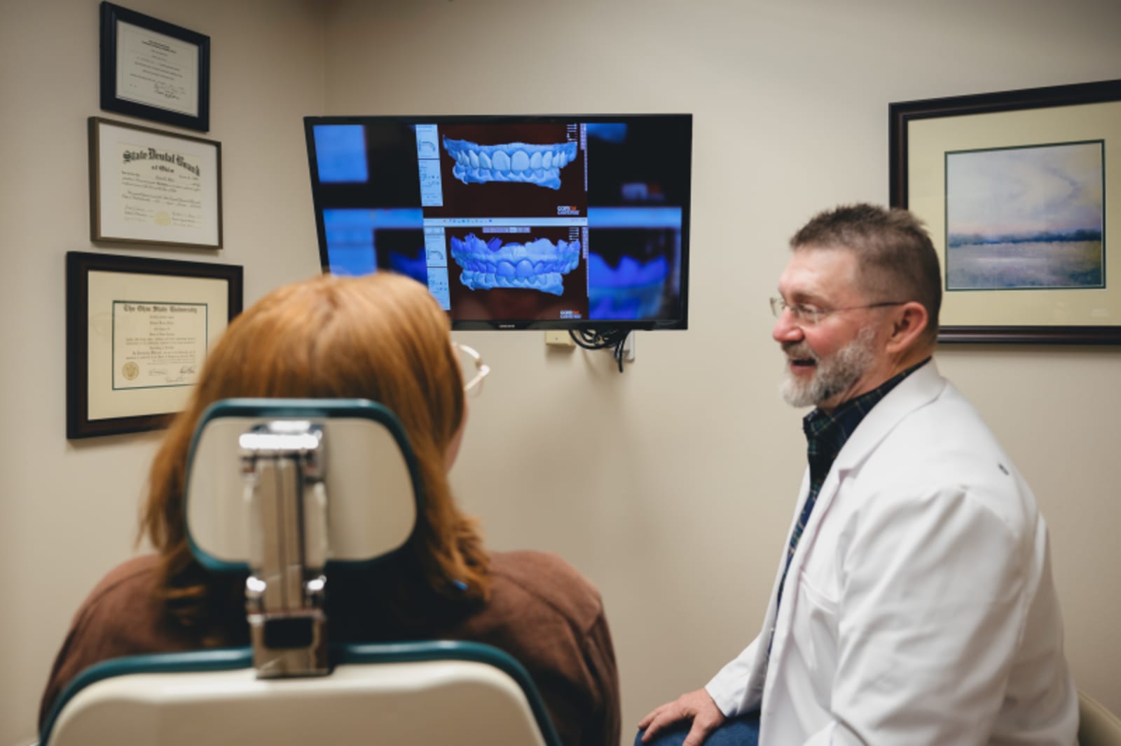 Dentist pointing to digital imaging of jaw on computer screen