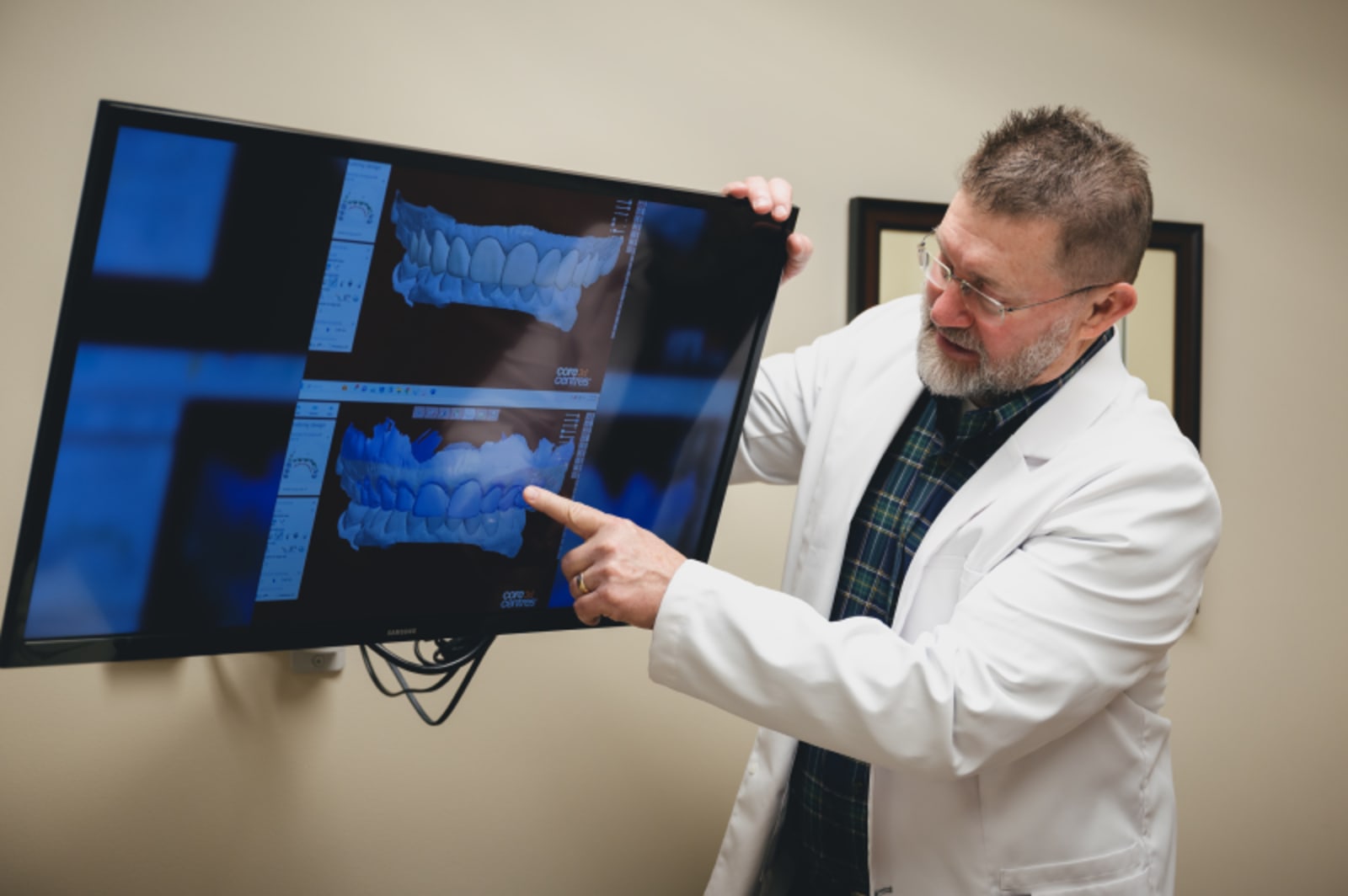 Dentist reviewing dental implant scans on monitors with patient