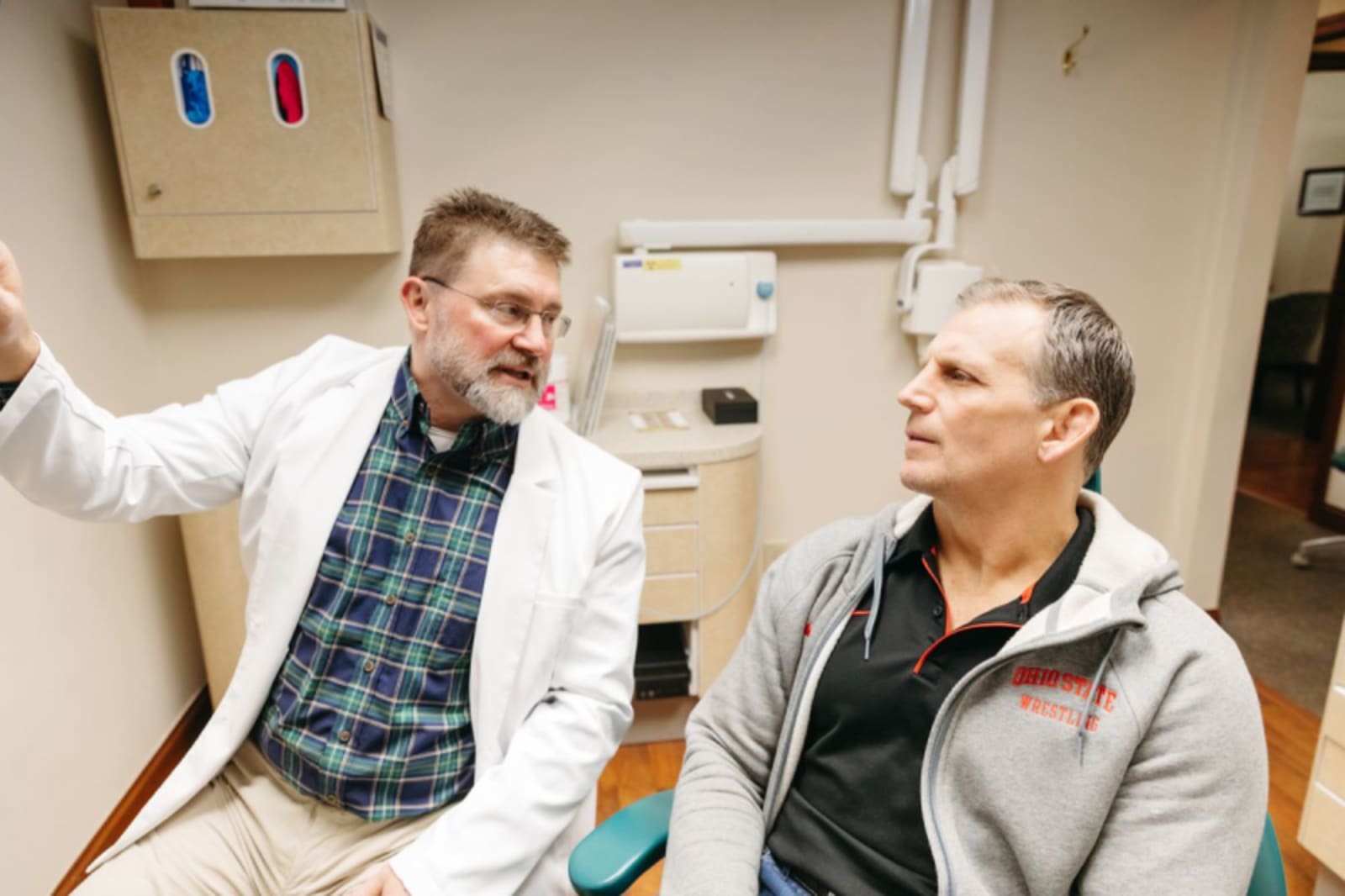 Dentist and patient discussing dental model and treatment maintenance requirements
