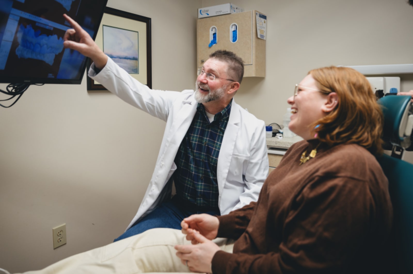 Dentist consulting with female patient in treatment room, explaining procedure options