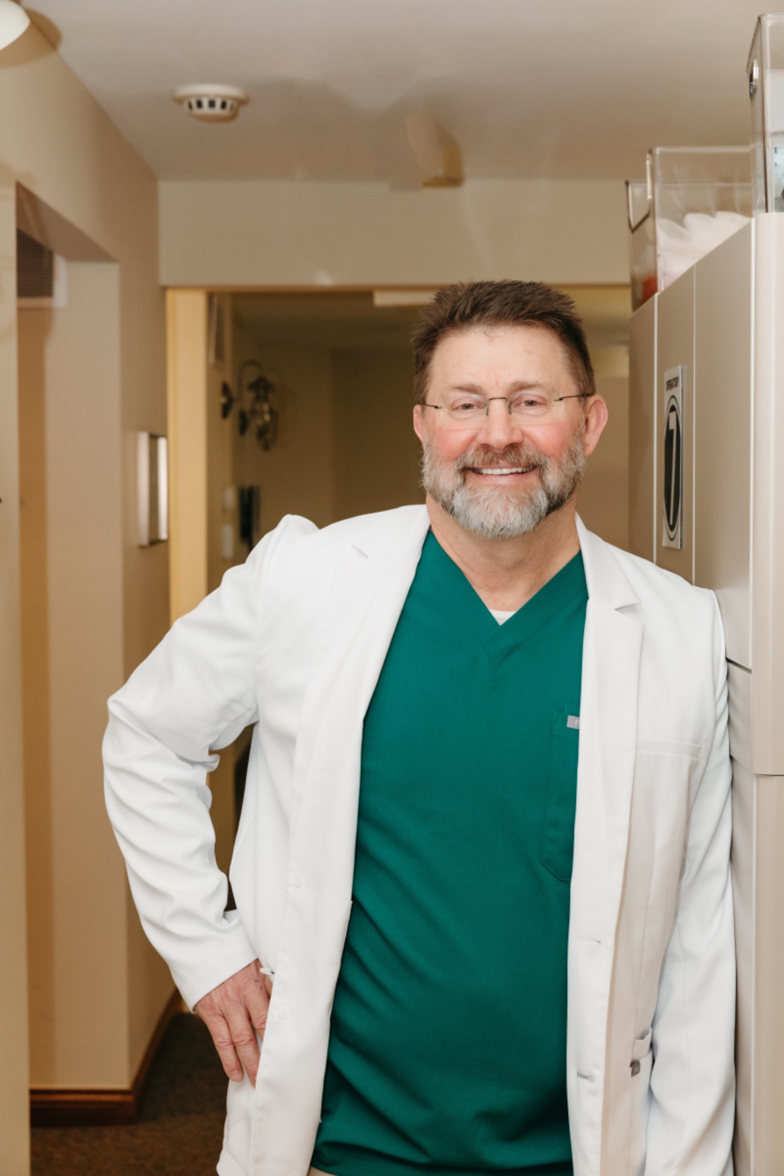 Portrait of dentist in white coat, professional surgeon in clinical setting