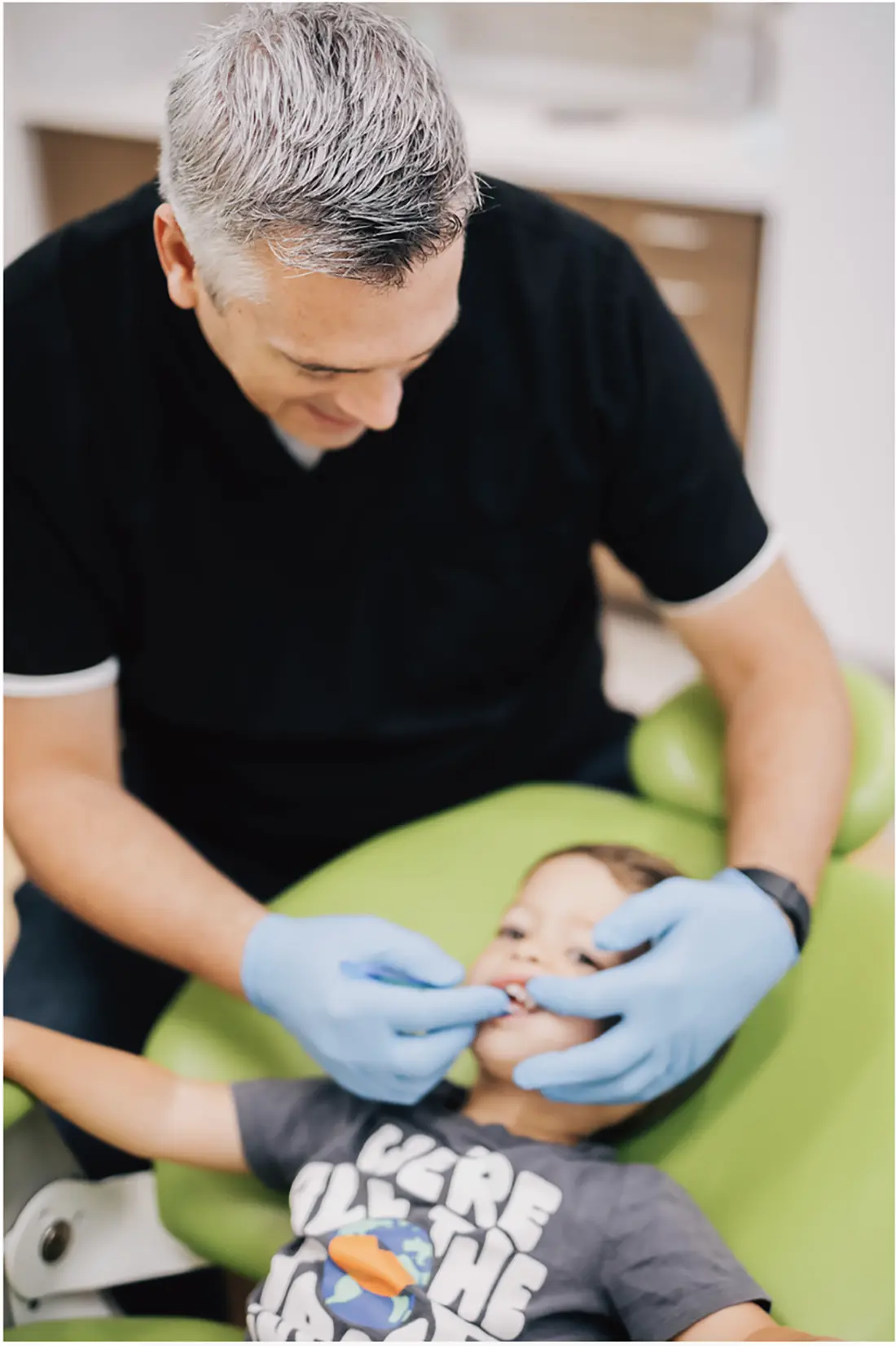 Pediatric dentist treating a child in the dental chair