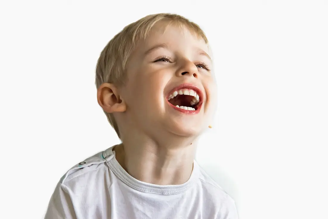 Young boy laughing with his mouth wide open
