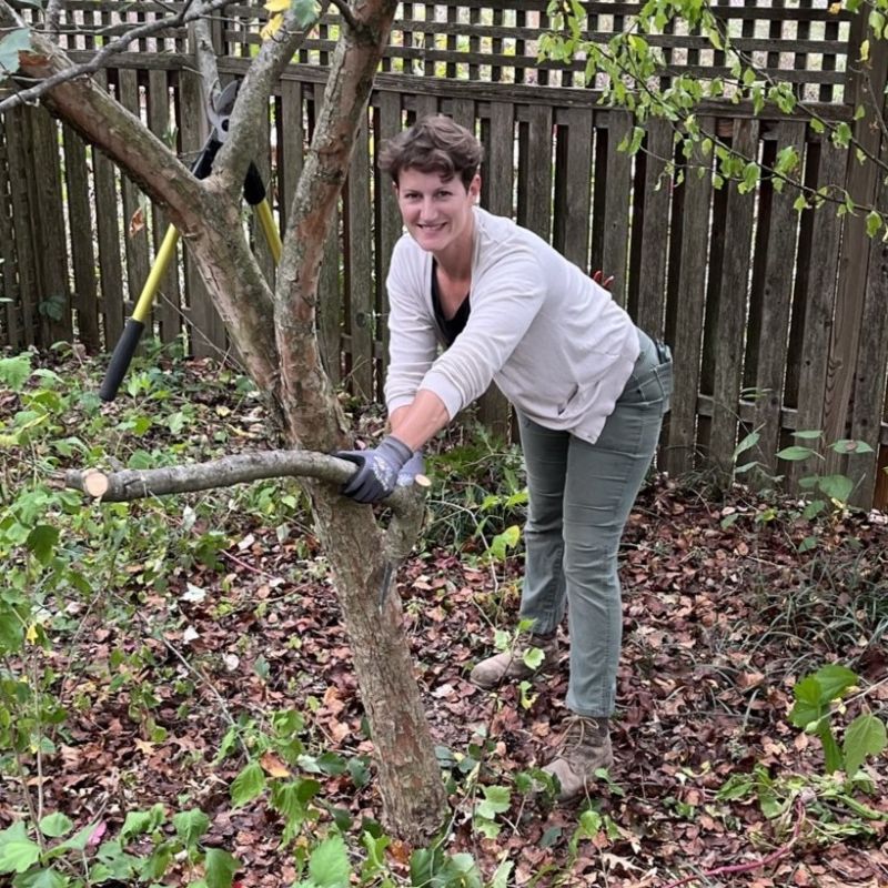 Carole Gardens' owner Meg McCollister in the field pruning a tree.