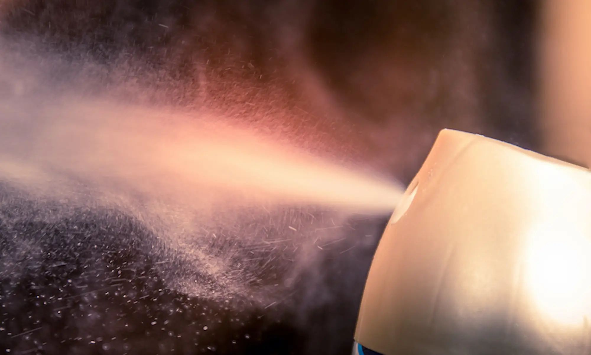 A close-up of the very first chemical aerosol air freshener as it sprays scent into a room.