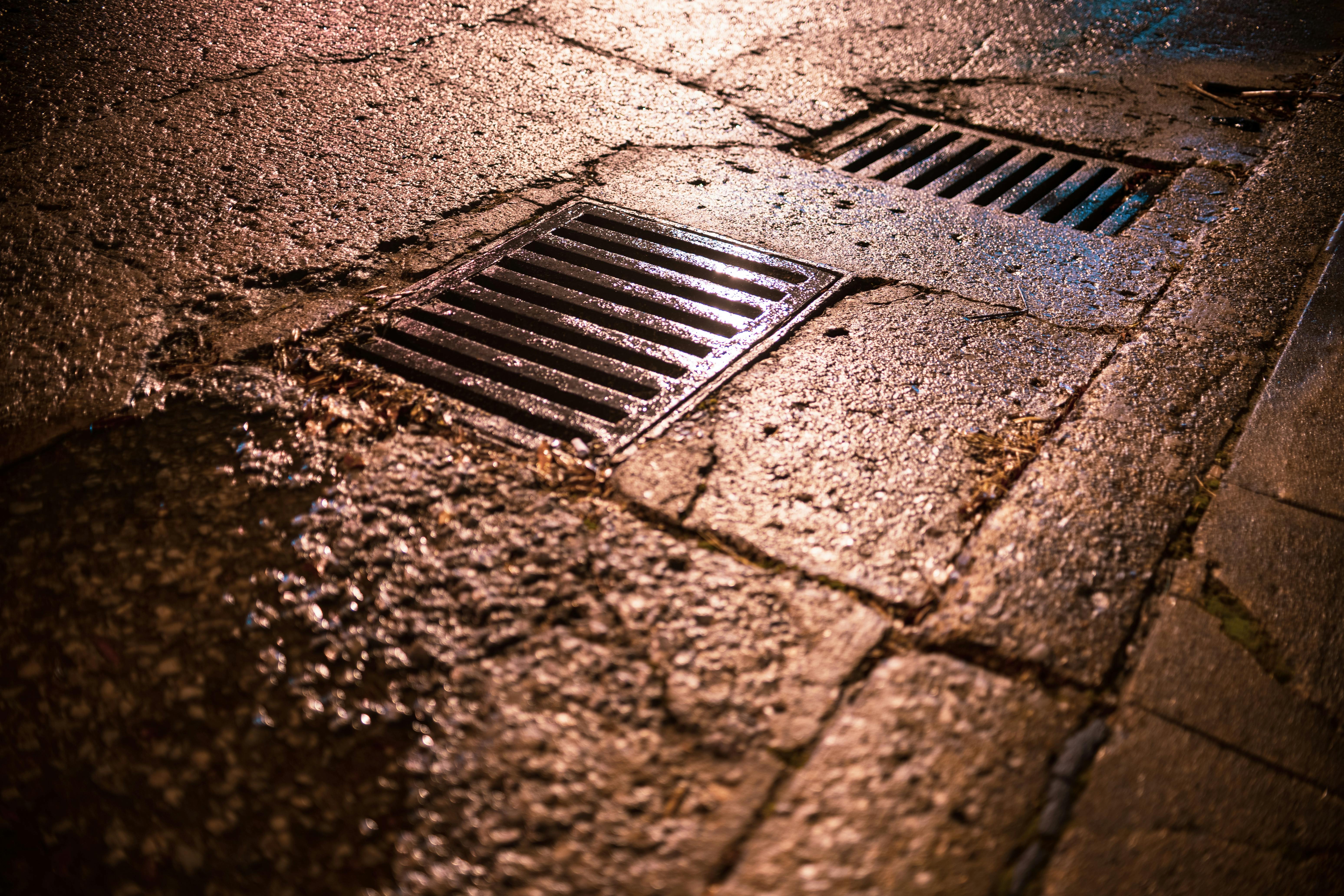 Metal Drainages on the Wet Asphalt Road · Free Stock Photo