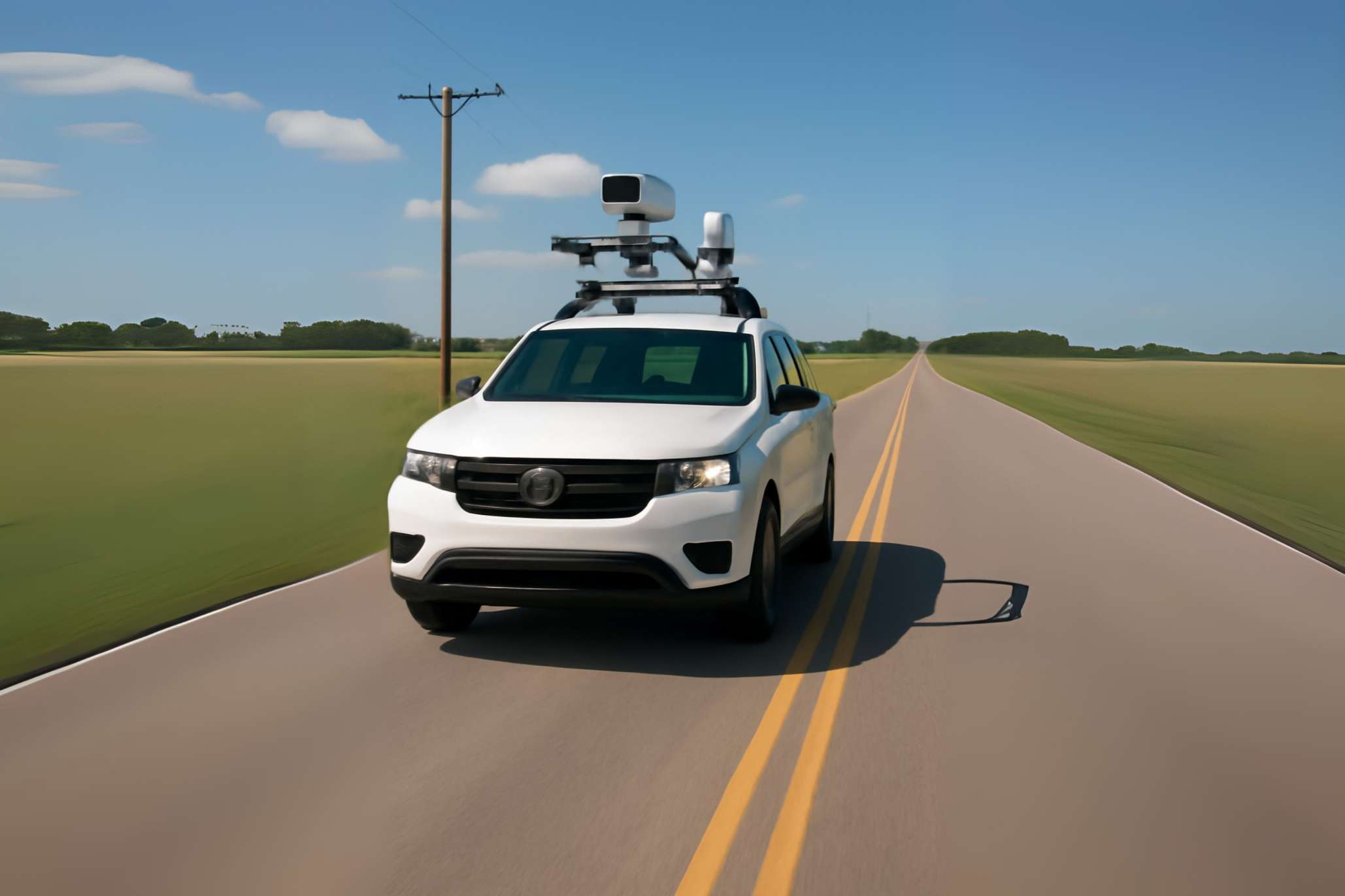 Road inspection vehicle on rural road in daylight.