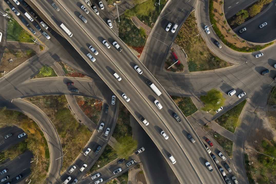 Aerial view of a busy multi-level highway interchange with cars and trucks.