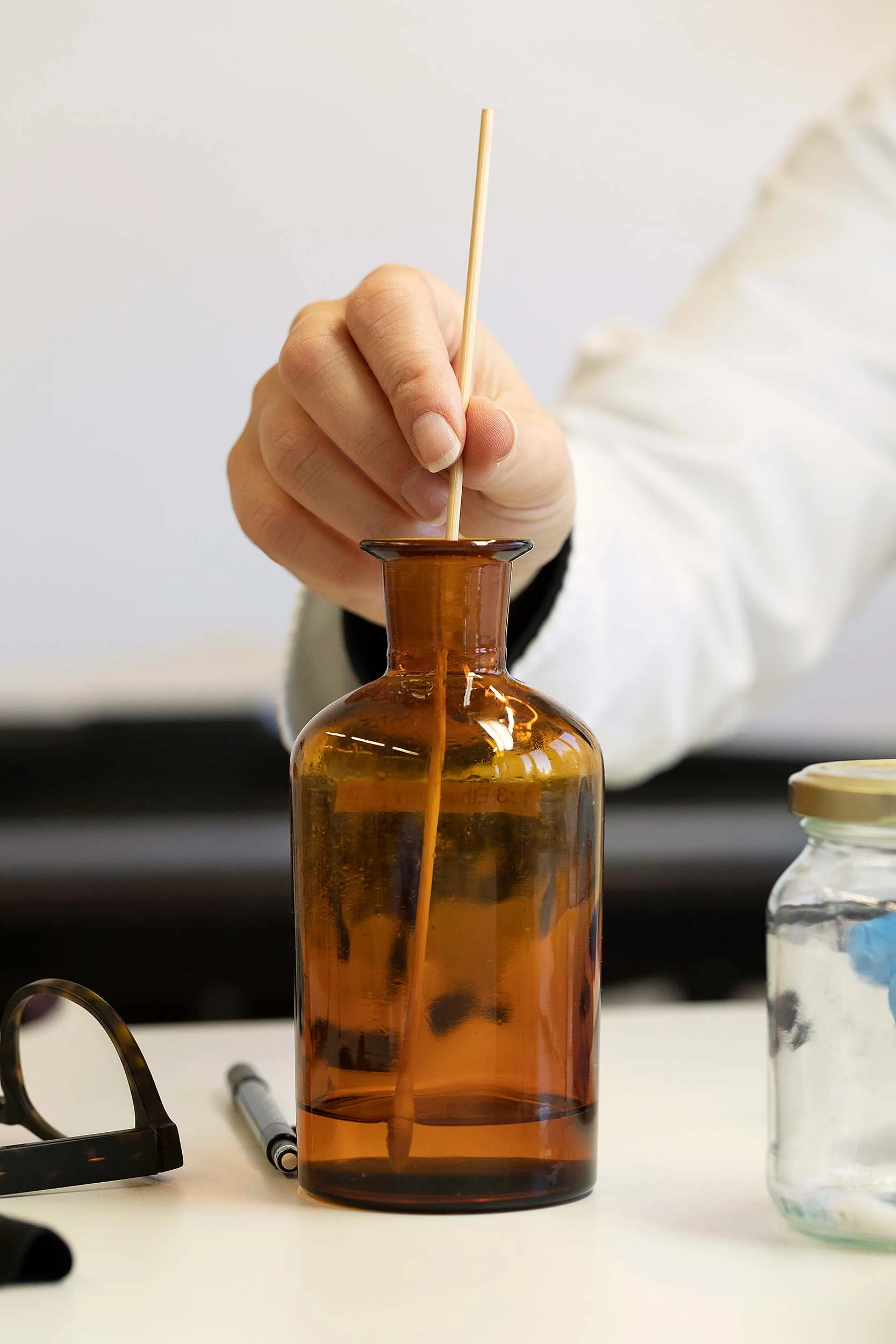 Nadine Reding schöpft mit einem Tupfer eine Flüssigkeit aus einem Apothekerglas.