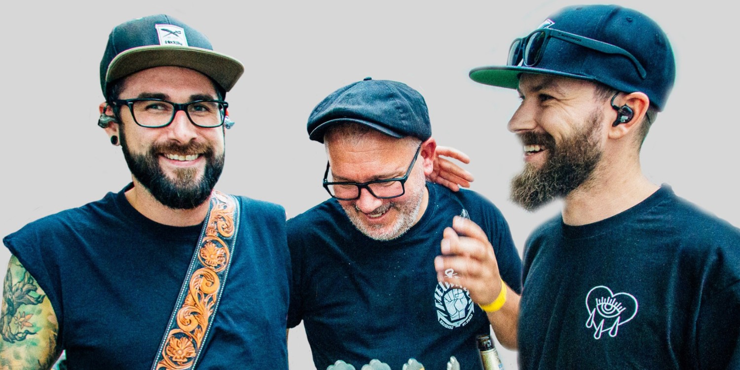 Die Bandmitglieder stehen lachend zusammen.