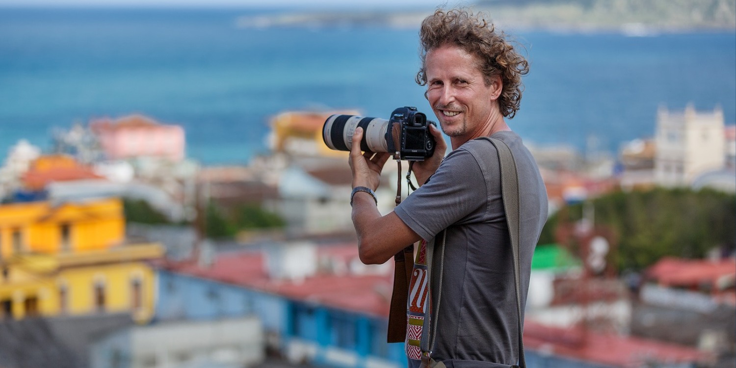 Foto von Tobias hauser mit Fotokamera in der Hand.
