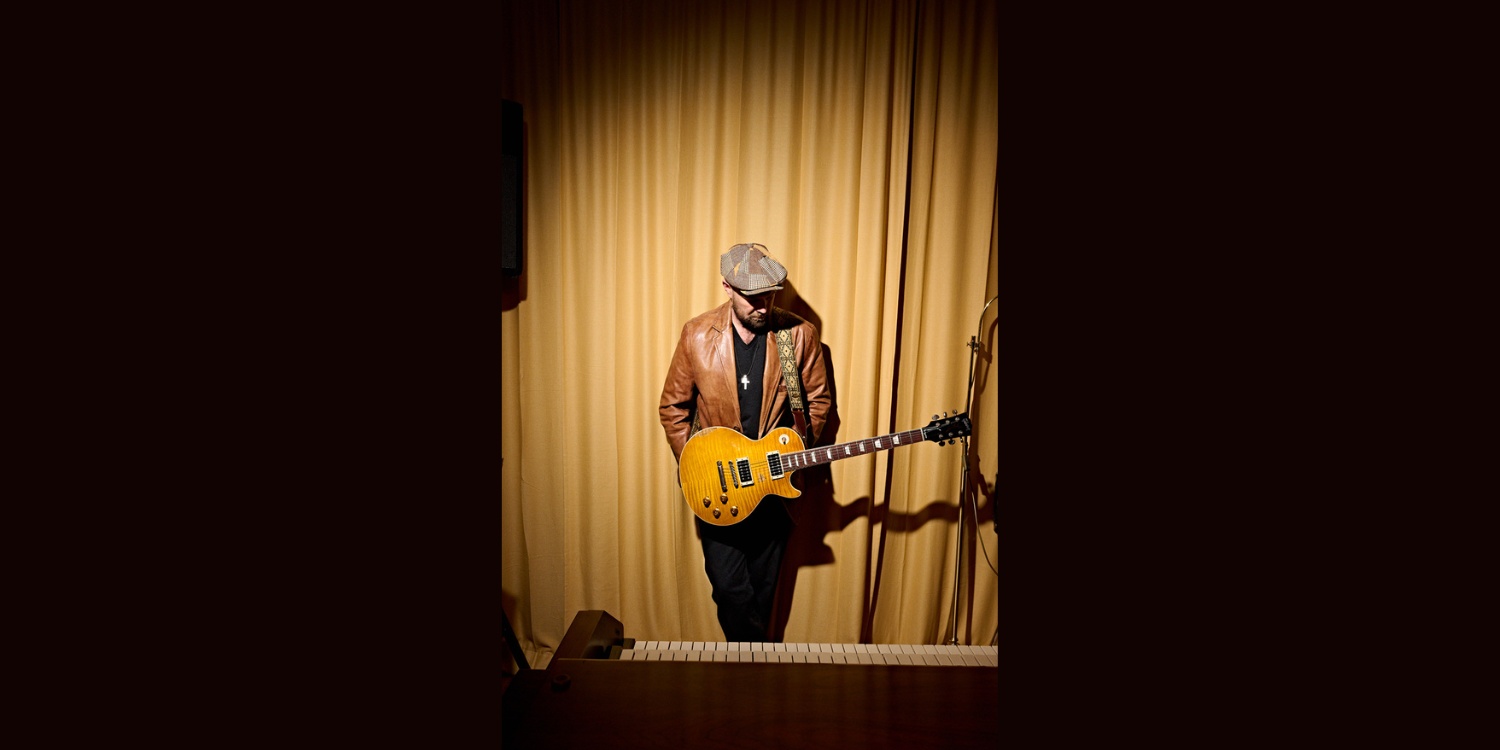 Henrik Freischlader mit Gitarre im Scheinwerferlicht.
