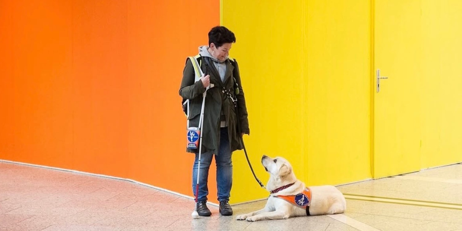 Eine Frau mit ihrem Blindenführhund.