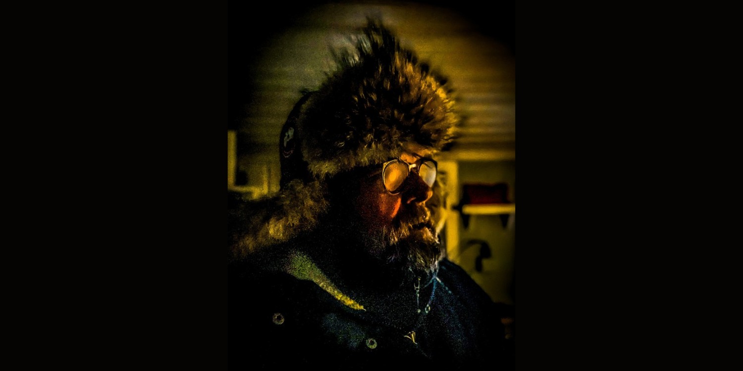 Jochen Malmsheimer im seitlichen Portrait mit Winterfell-Mütze auf.