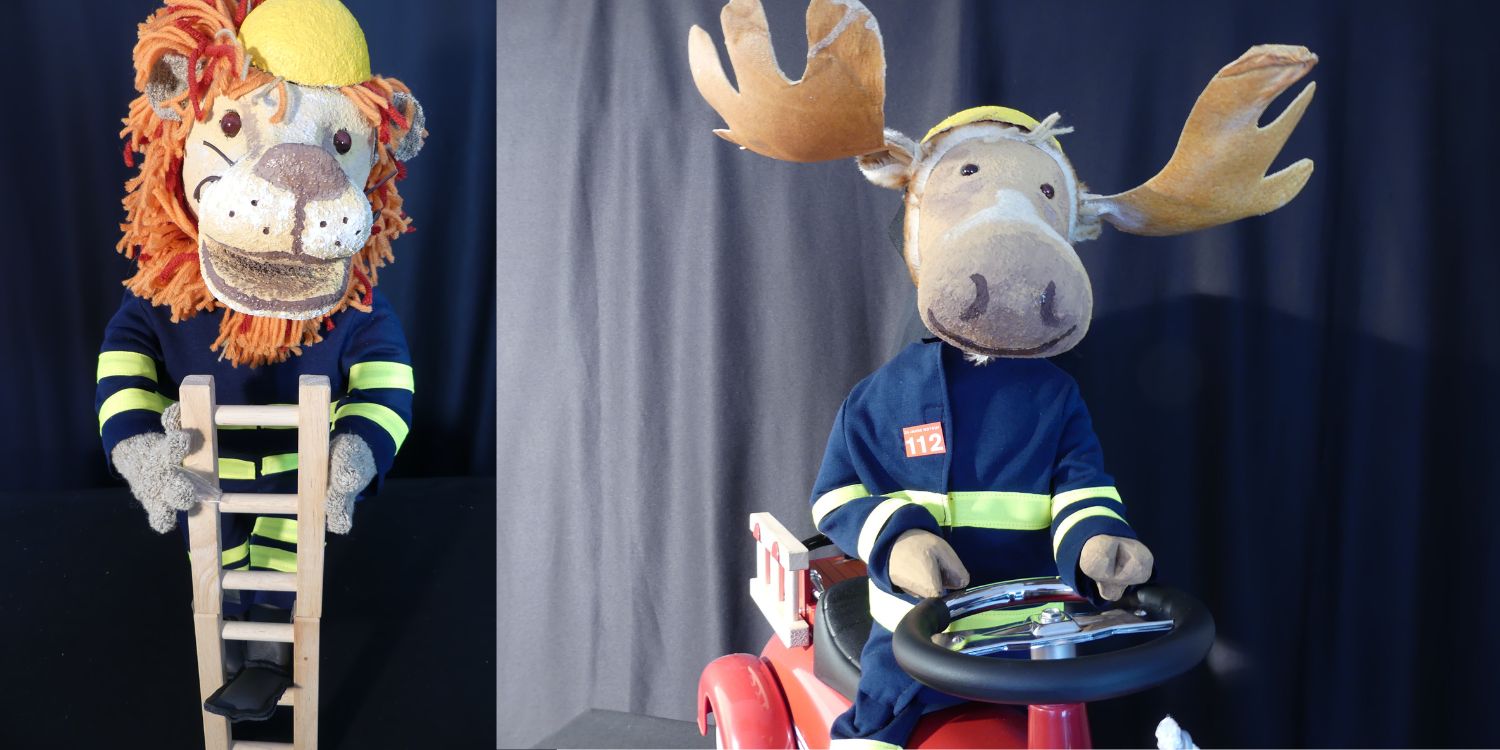 Die Figuren Finn, der Feuerwehrelch auf einem Feuerwehrauto und ein Löwe mit Leiter.