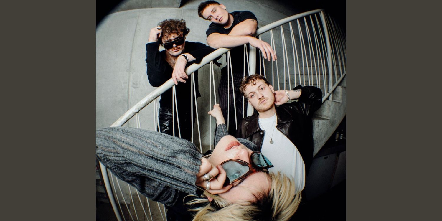 Die Band in einem Treppenhaus posierend.