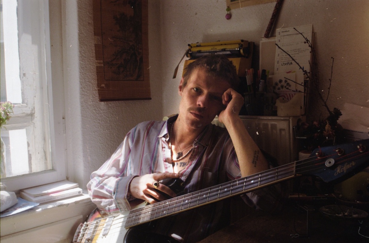 Jesper Munk sitzend mit Gitarre.