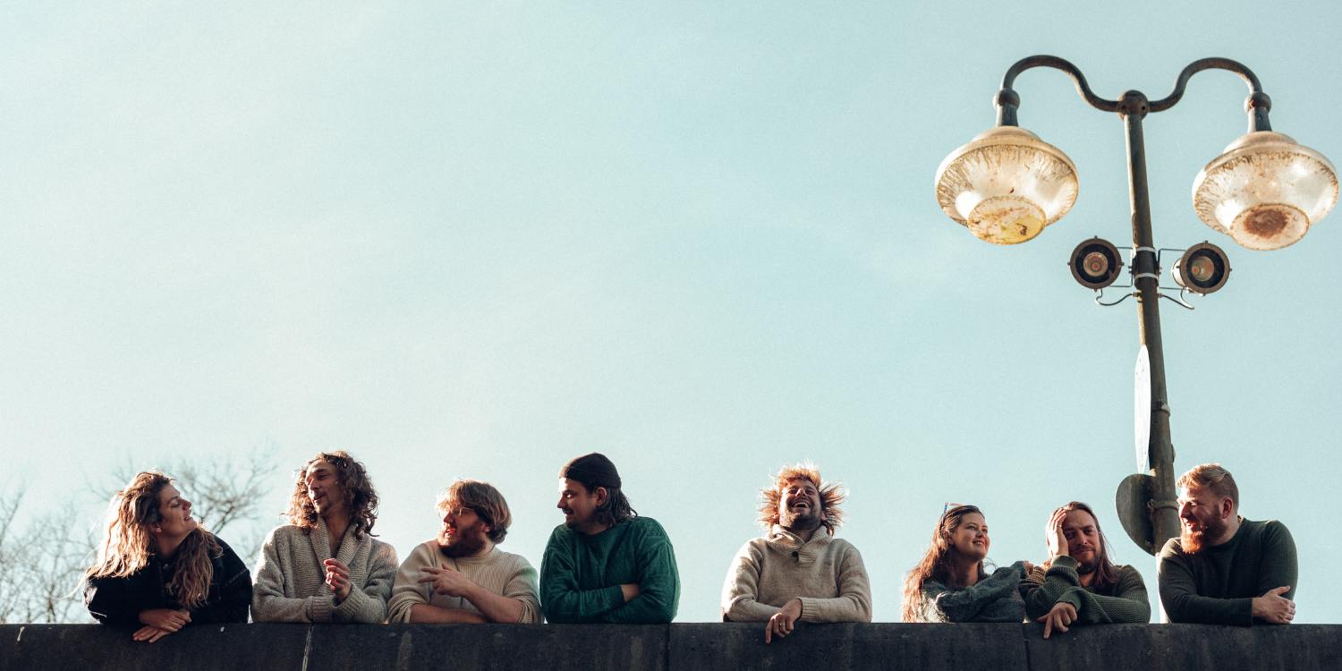 Die Band The Magic Mumble Jumble steht gegen eine Mauer gelehnt.