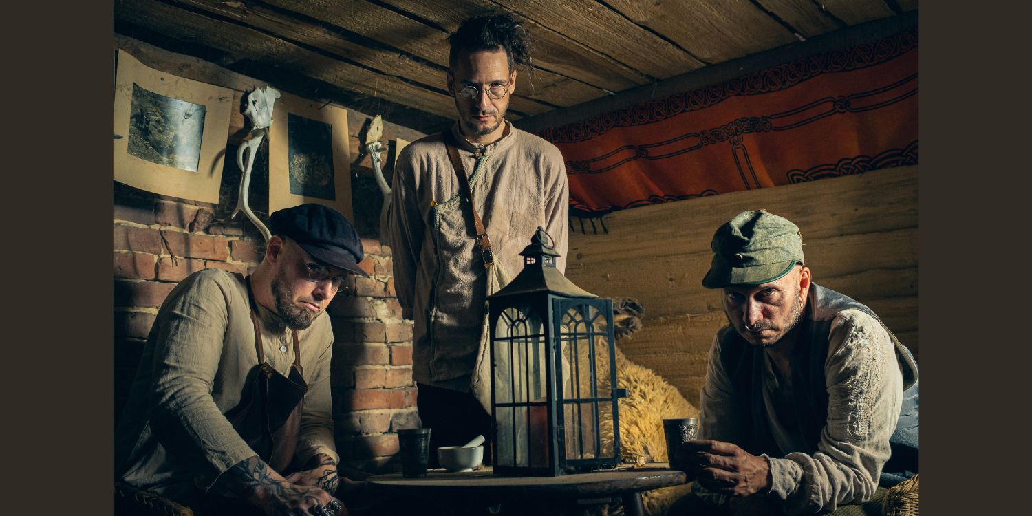 Die 3 Bandmitglieder von The Hirsch Effekt in einer alten Hütte sitzend.
