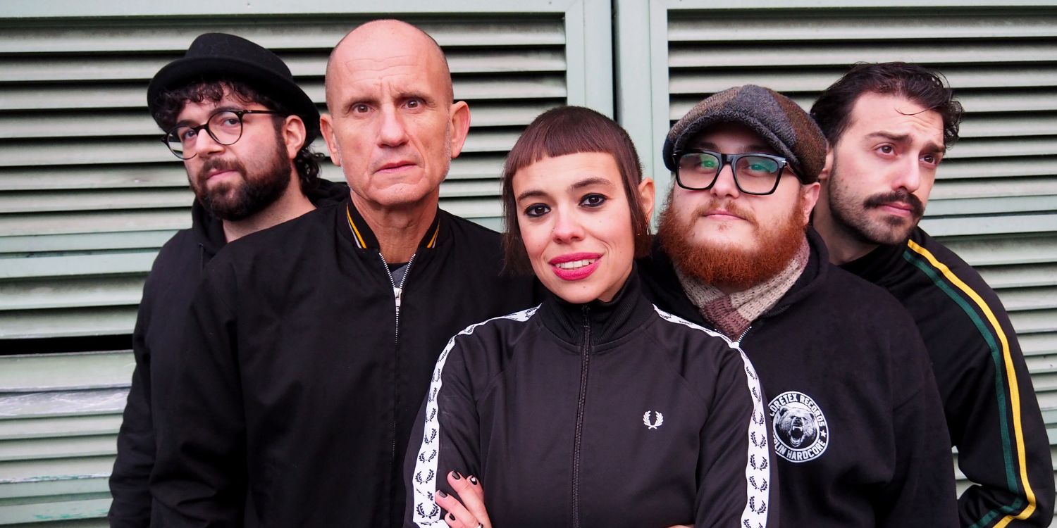 Die fünf Bandmitglieder stehen vor einem Rolltor