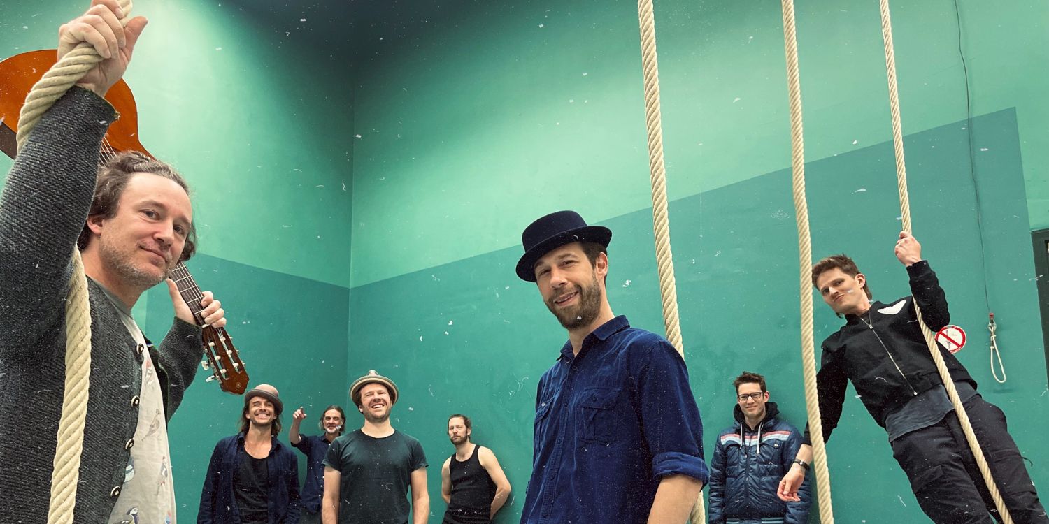 Die Band Jamaram und der Künstler Jahcoustix verteilt in einem Raum.
