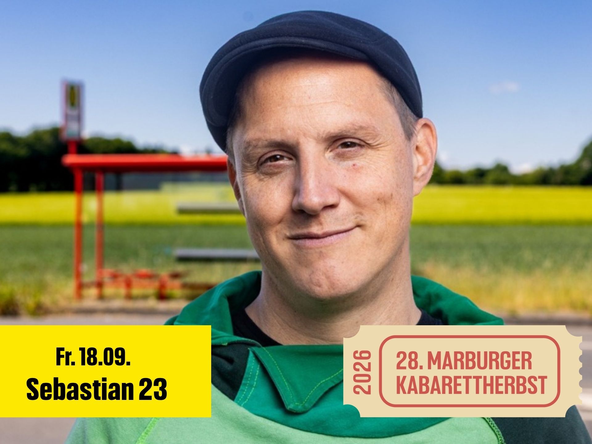 Mann mit Kappe steht vor einer Bushaltestelle