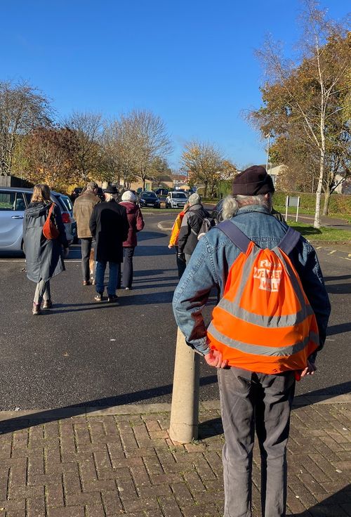 A sunny day and a group of walkers are setting off on their walk.